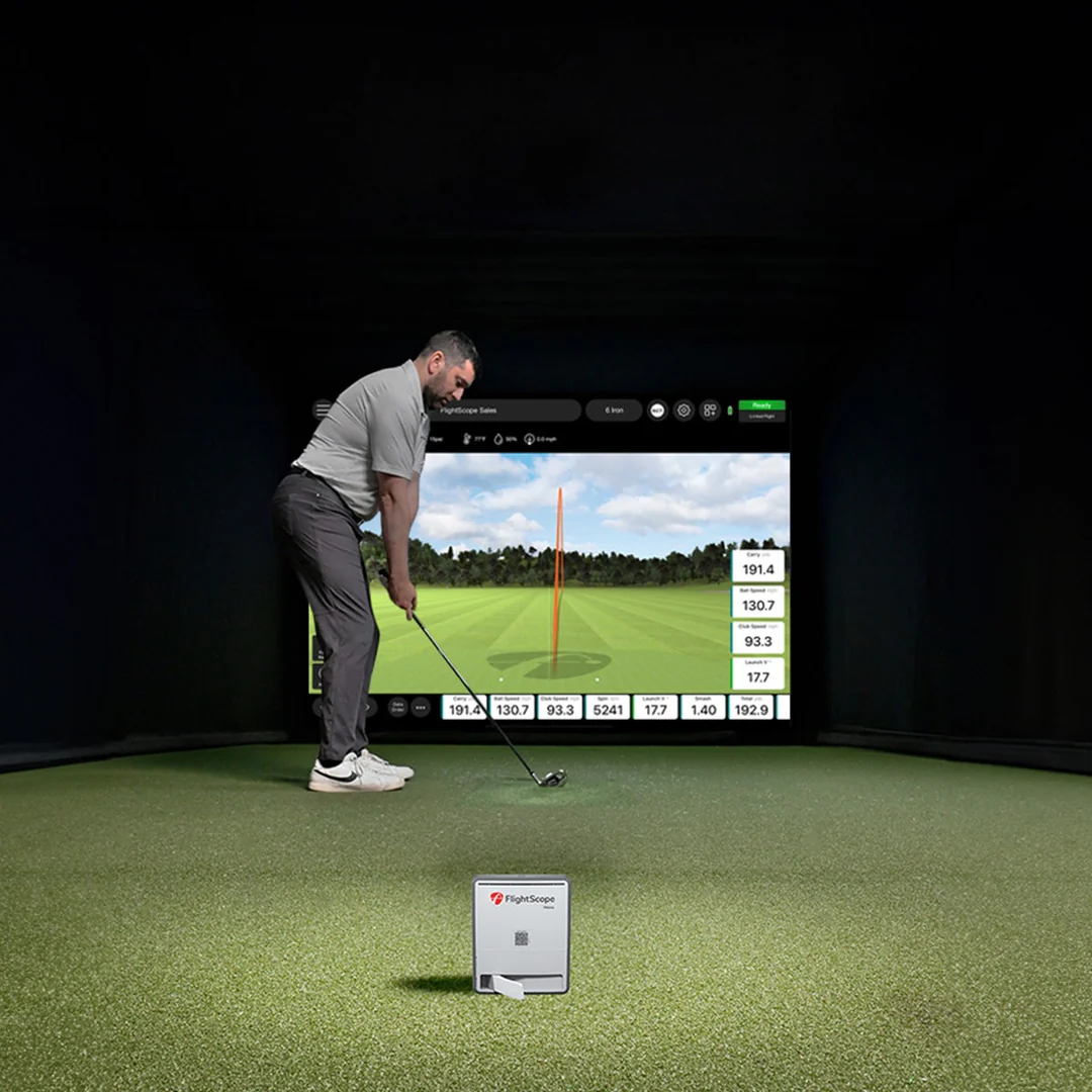 FlightScope Mevo Gen 2 indoor golf simulator with golfer and screen