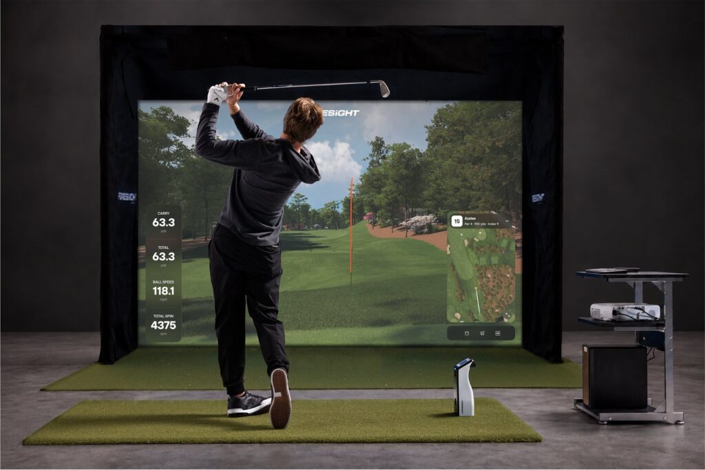 A Foresight GC2 launch monitor beside the ball in a golf simulator bay