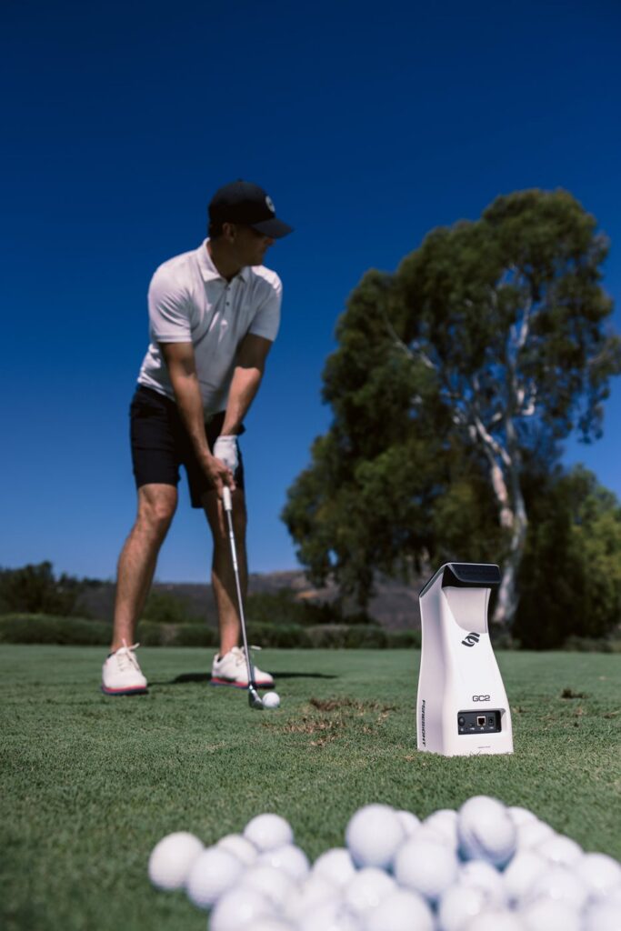 Foresight GC2 launch monitor on a grass range beside a golfer