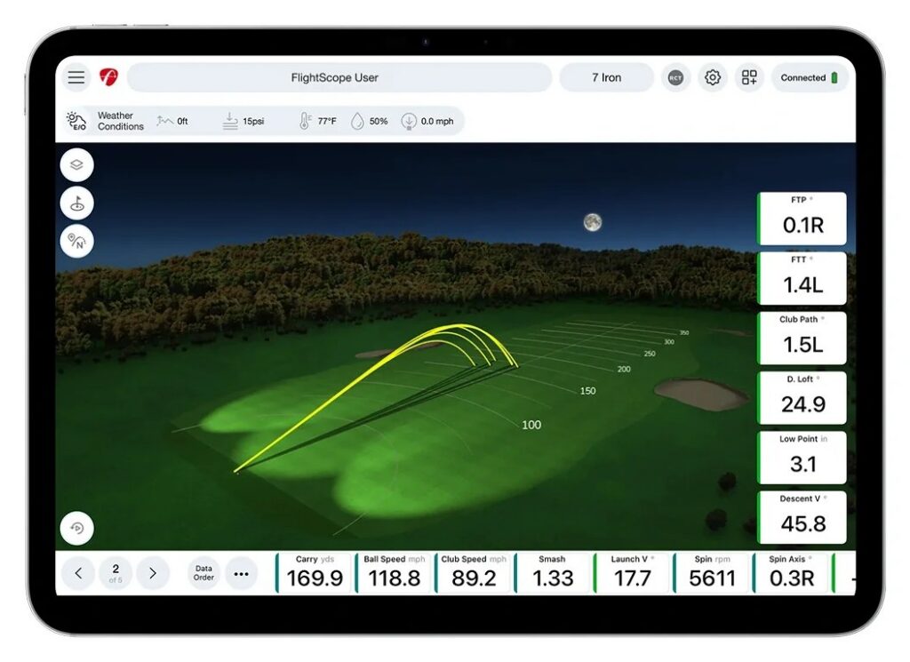 FS Golf app on a tablet showing the new trajectory view with the night sky, shot traces on the range and data tiles for a 7 iron