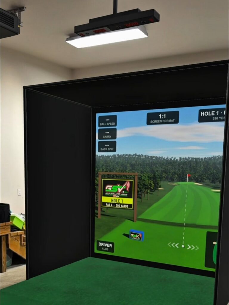 A golf simulator enclosure, screen, hitting mat and ceiling-mounted launch monitor shown at true size in a garage through augmented reality