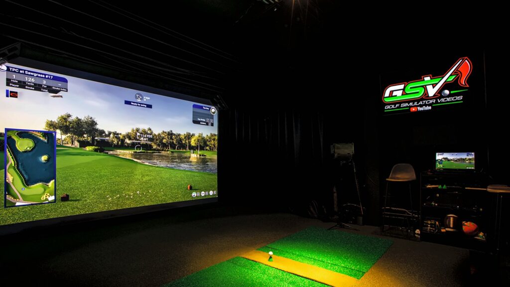 GSV basement studio with a built-in screen showing the 17th hole at TPC Sawgrass, black curtains, a light over the hitting mats and the GSV sign